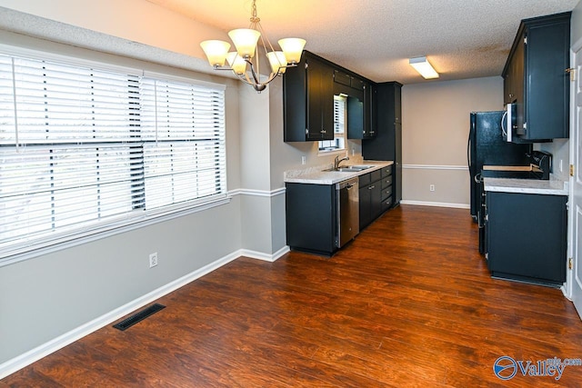 kitchen with sink, an inviting chandelier, a textured ceiling, appliances with stainless steel finishes, and dark hardwood / wood-style flooring