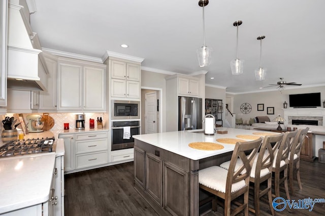 kitchen with custom range hood, open floor plan, stainless steel appliances, light countertops, and backsplash