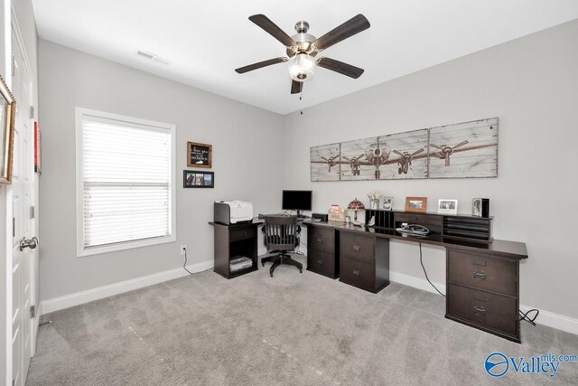 carpeted office space featuring visible vents, baseboards, and ceiling fan