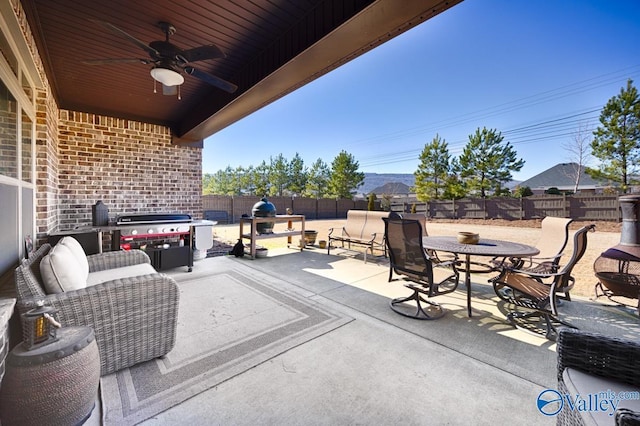 view of patio / terrace with ceiling fan, a grill, a fenced backyard, and outdoor dining space