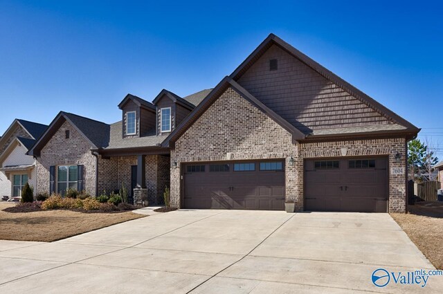 view of front facade with concrete driveway, brick siding, and an attached garage