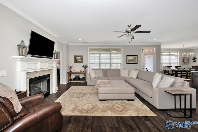 living area featuring dark wood-type flooring, a fireplace, a wealth of natural light, and crown molding