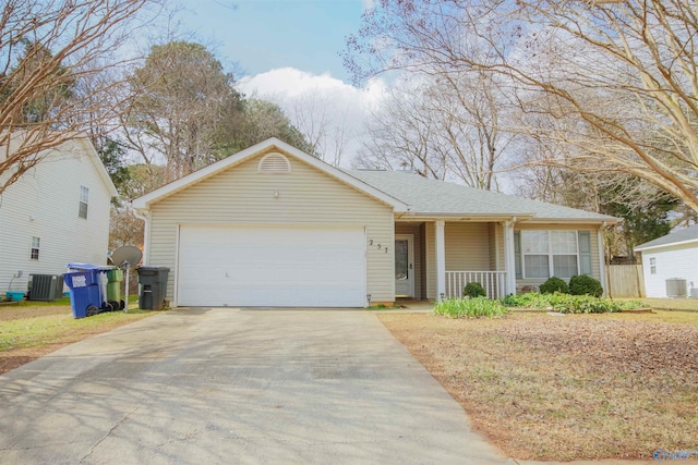 ranch-style house with a porch, driveway, an attached garage, and central air condition unit