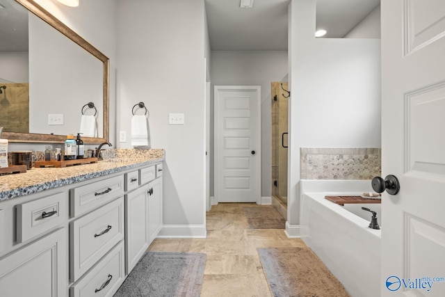 3015 Peevey Creek Ln, Owens Cross Roads, AL 35763 - bathroom featuring vanity, a shower stall, a garden tub, and baseboards