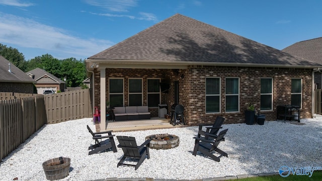3015 Peevey Creek Ln, Owens Cross Roads, AL 35763 - back of property with a patio area, a fenced backyard, brick siding, a shingled roof, and an outdoor living space with a fire pit