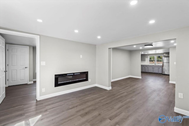 unfurnished living room featuring dark wood-type flooring