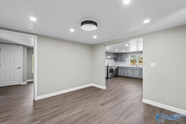 kitchen with gray cabinets, dark wood-type flooring, and electric stove