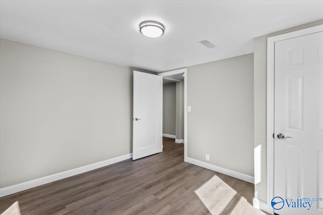 unfurnished bedroom with dark wood-type flooring