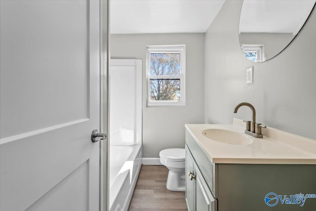 full bathroom with vanity, wood-type flooring, toilet, and tub / shower combination