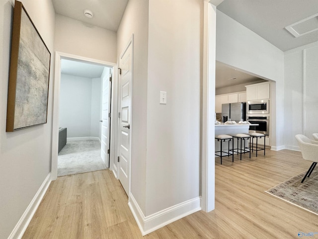 corridor with light hardwood / wood-style flooring