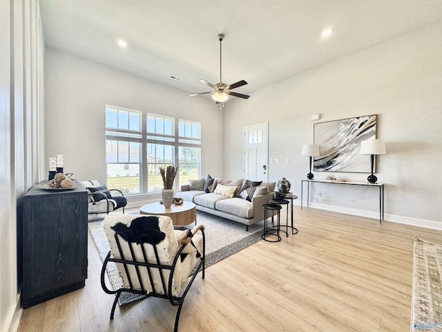 living room with ceiling fan and light hardwood / wood-style flooring