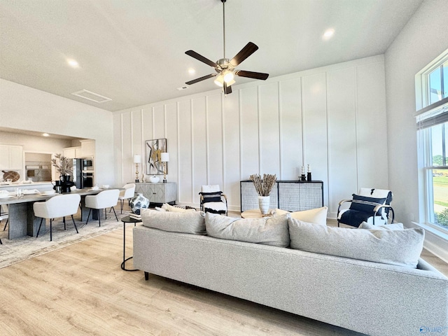 living room with a healthy amount of sunlight, ceiling fan, and light hardwood / wood-style flooring