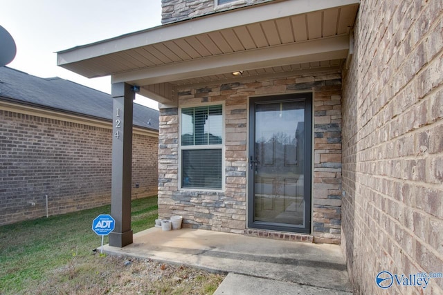 property entrance featuring stone siding and brick siding