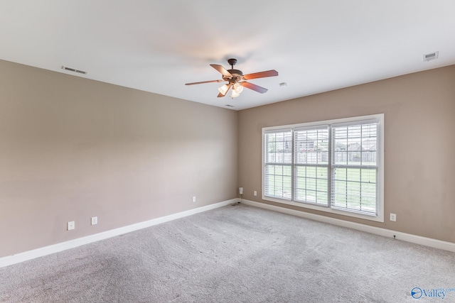 carpeted spare room featuring ceiling fan