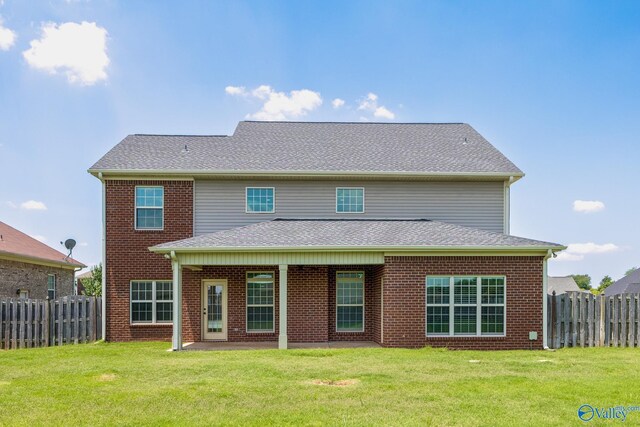 rear view of house featuring a yard