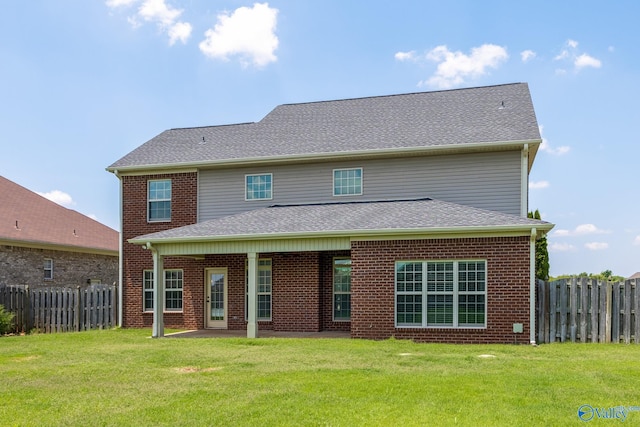 rear view of house featuring a yard