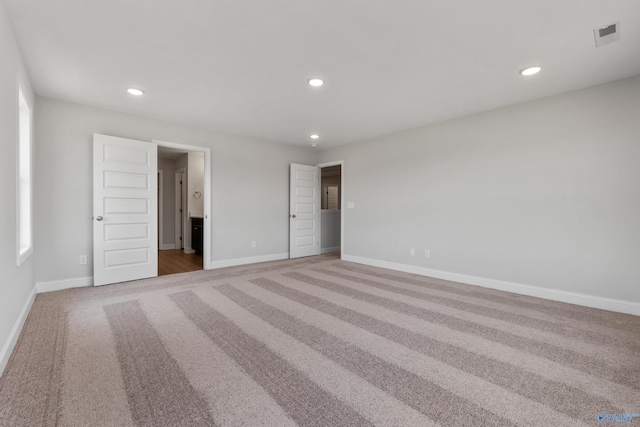 unfurnished bedroom featuring a tray ceiling and light carpet