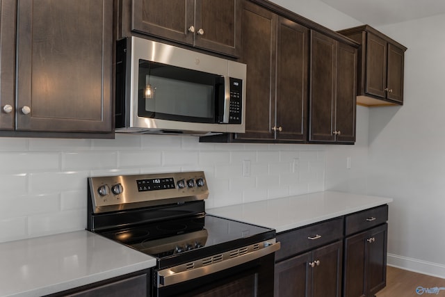 kitchen featuring a kitchen island, appliances with stainless steel finishes, decorative light fixtures, sink, and light hardwood / wood-style flooring