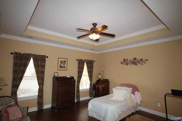 bedroom with ceiling fan, dark wood-type flooring, a tray ceiling, and multiple windows