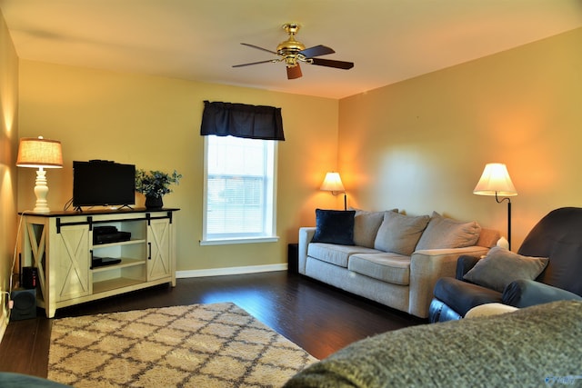 living room featuring ceiling fan and dark wood-type flooring