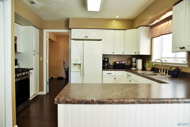 kitchen featuring white refrigerator with ice dispenser, white cabinets, sink, gas stove, and dark hardwood / wood-style flooring