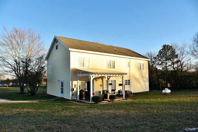 back of property featuring a lawn and a pergola