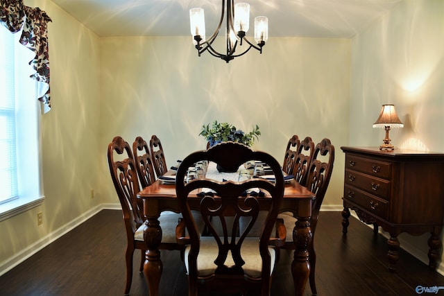 dining space featuring dark hardwood / wood-style flooring and an inviting chandelier