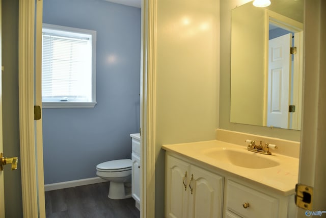 bathroom with hardwood / wood-style floors, vanity, and toilet