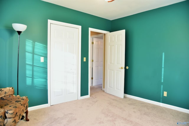 unfurnished bedroom with light carpet and a closet