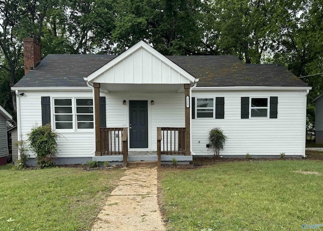 2217 Beasley Ave NW, Huntsville, AL 35816 - view of front of home with a chimney, a front lawn, a shingled roof, and board and batten siding