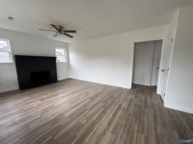 2217 Beasley Ave NW, Huntsville, AL 35816 - unfurnished living room featuring a ceiling fan, a brick fireplace, dark wood finished floors, and baseboards