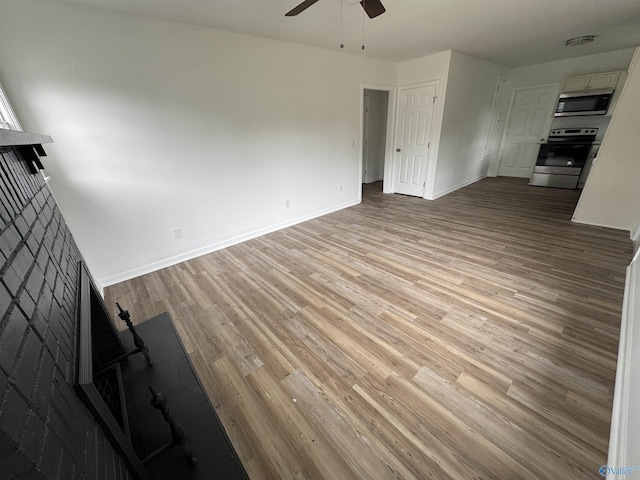 2217 Beasley Ave NW, Huntsville, AL 35816 - unfurnished living room with a ceiling fan, wood finished floors, baseboards, and a fireplace