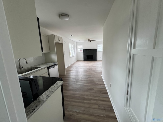 2217 Beasley Ave NW, Huntsville, AL 35816 - kitchen featuring a sink, ceiling fan, dark wood-type flooring, a fireplace, and baseboards