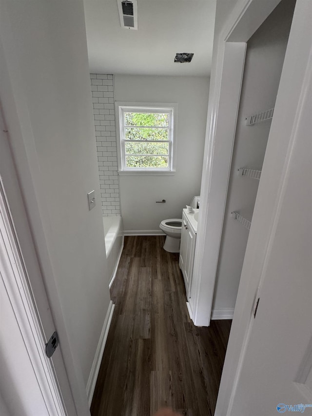 2217 Beasley Ave NW, Huntsville, AL 35816 - bathroom featuring wood finished floors, toilet, baseboards, vanity, and a tub to relax in