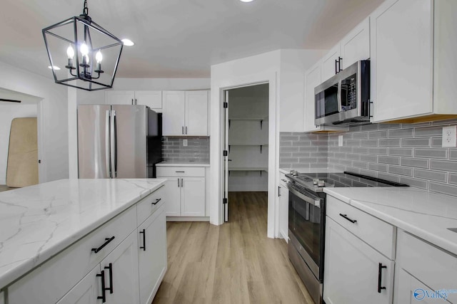 kitchen featuring appliances with stainless steel finishes, light wood-type flooring, and white cabinetry