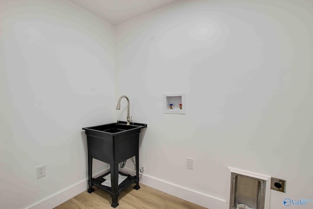 washroom with hookup for an electric dryer, washer hookup, and light wood-type flooring