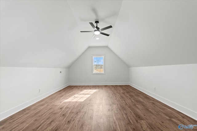 additional living space with baseboards, vaulted ceiling, a ceiling fan, and wood finished floors