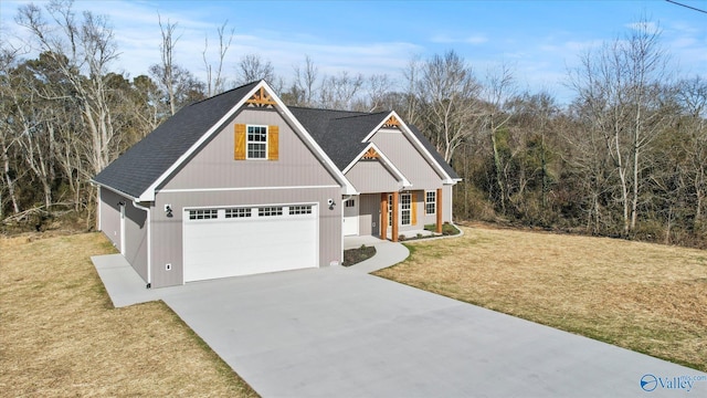 view of front of home featuring an attached garage, roof with shingles, driveway, and a front yard