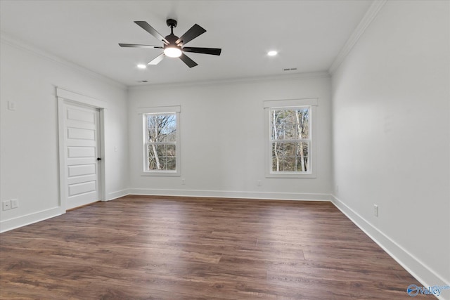 spare room with a ceiling fan, crown molding, dark wood finished floors, visible vents, and baseboards
