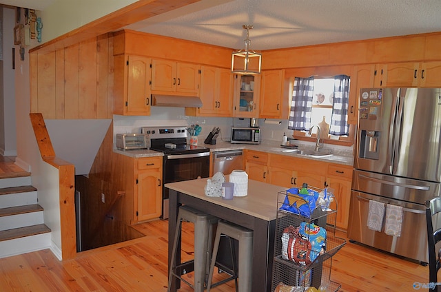 kitchen with backsplash, stainless steel appliances, light hardwood / wood-style flooring, and sink