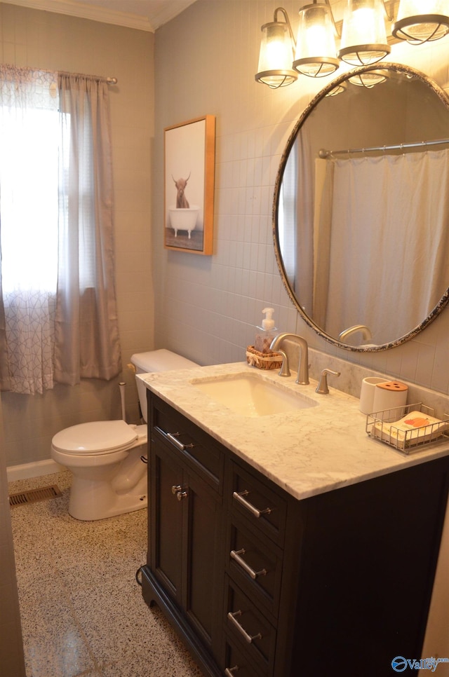 bathroom featuring vanity, toilet, tile walls, and crown molding