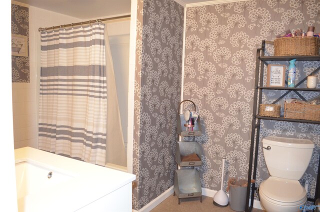 bathroom featuring a shower with shower curtain, toilet, and ornamental molding