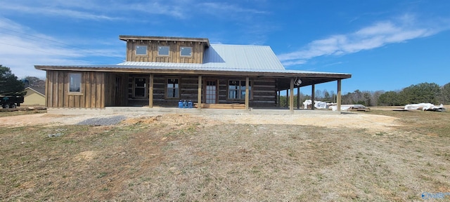 back of house with metal roof and a porch