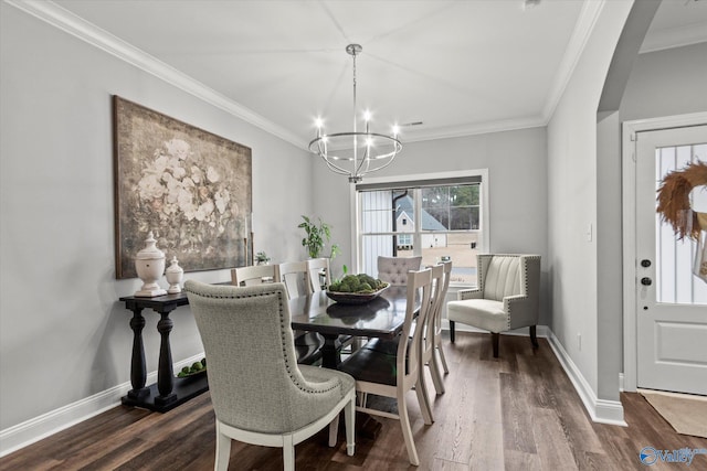 dining room with a chandelier, crown molding, and dark wood-type flooring