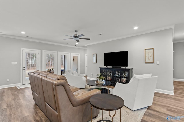 living room featuring light wood-type flooring, ceiling fan, and ornamental molding