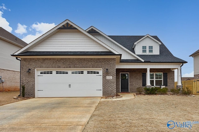 craftsman house with a garage, concrete driveway, brick siding, and a porch