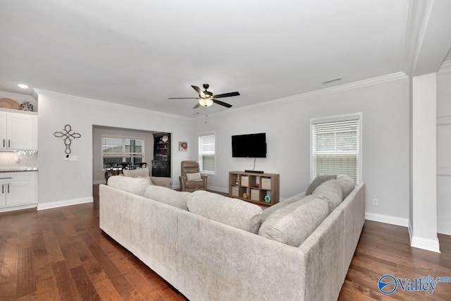 living room featuring dark wood-style floors, ornamental molding, baseboards, and ceiling fan