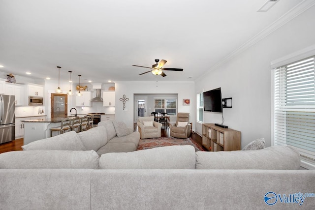 living room with visible vents, a ceiling fan, dark wood-style floors, crown molding, and recessed lighting