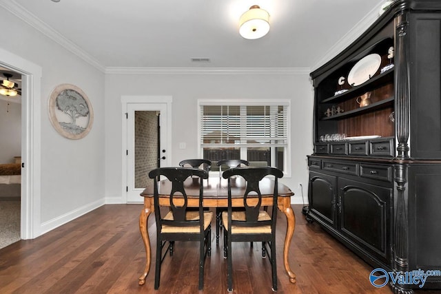 dining area with baseboards, visible vents, dark wood-type flooring, and crown molding