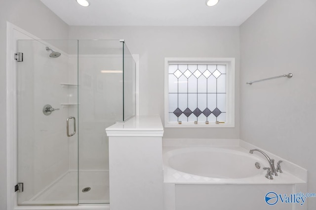 bathroom featuring a shower stall, a bath, and recessed lighting